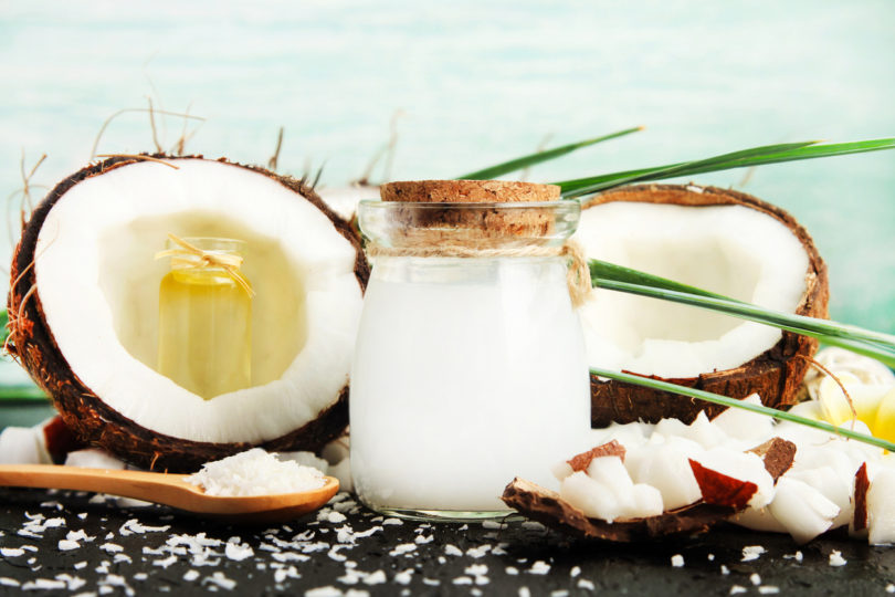 Coconut split in half and jar containing coconut milk outside