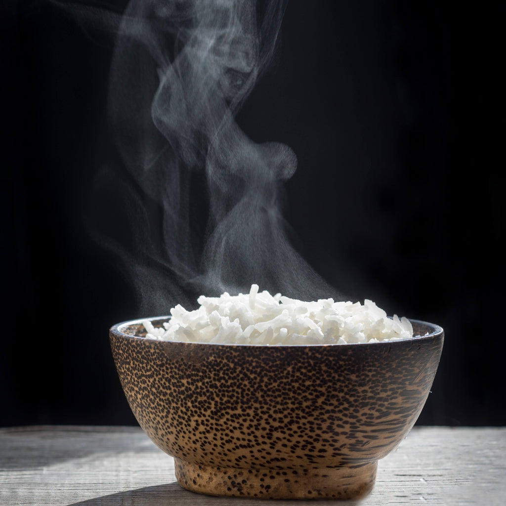Wooden bowl of steaming rice