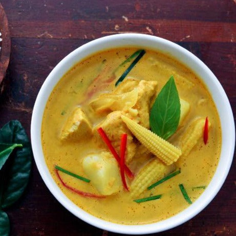 Yellow chicken curry on wooden table